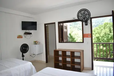 a bedroom with a bed and a window with a fan at hotel bocas del cauca in Tarso
