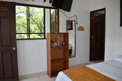 a bedroom with a bed and a dresser and a window at hotel bocas del cauca in Tarso