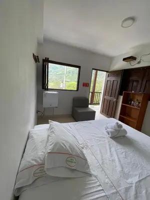a large white bed in a room with a window at hotel bocas del cauca in Tarso