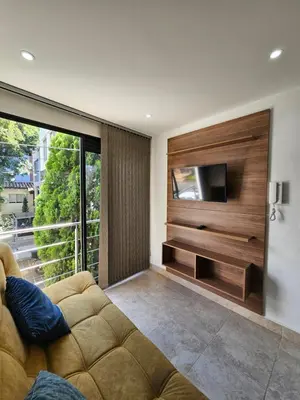 a living room with a couch and a flat screen tv at Medellín te Espera Modern & Central Apartment for Travelers in Medellín