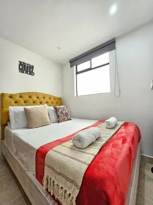 a bedroom with a large bed with a red blanket at Medellín te Espera Modern & Central Apartment for Travelers in Medellín
