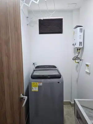 a small refrigerator in a kitchen next to a door at Medellín te Espera Modern & Central Apartment for Travelers in Medellín