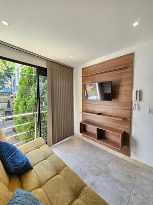 a living room with a couch and a flat screen tv at Medellín te Espera Modern & Central Apartment for Travelers in Medellín