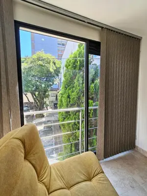 a living room with a large window and a couch at Medellín te Espera Modern & Central Apartment for Travelers in Medellín