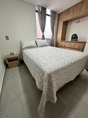 a bedroom with a large bed and a window at A home away from home! in Medellín