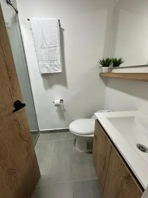 a white bathroom with a toilet and a sink at A home away from home! in Medellín