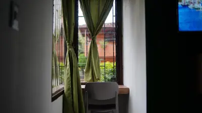 a window with curtains and a chair in a room at Olivo House Casa Hotel in Envigado