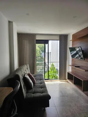 a living room with a couch and a large window at Moderno & Central, descubre medellin desde Laureles in Medellín