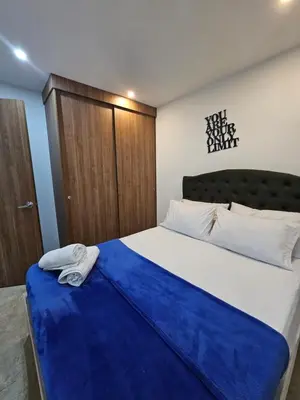 a bedroom with a large bed with a blue blanket at Moderno & Central, descubre medellin desde Laureles in Medellín
