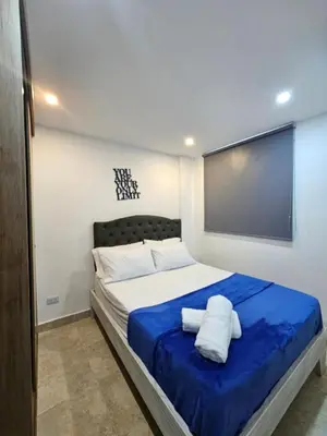 a bedroom with a large bed with a blue blanket at Moderno & Central, descubre medellin desde Laureles in Medellín