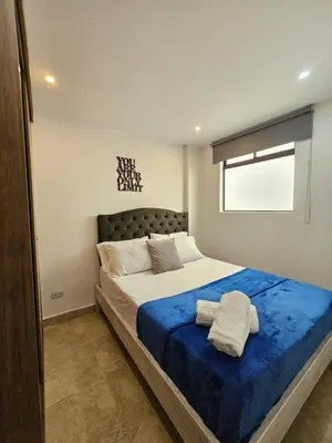 a bedroom with a large bed with a blue blanket at Moderno & Central, descubre medellin desde Laureles in Medellín