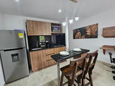 a kitchen with a table with chairs and a refrigerator at Moderno & Central, descubre medellin desde Laureles in Medellín