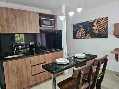 a kitchen with a table with chairs and a microwave at Moderno & Central, descubre medellin desde Laureles in Medellín