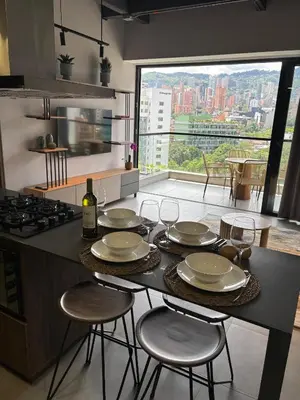 a kitchen with a table with plates and wine glasses at Apto Bonito Poblado in Medellín