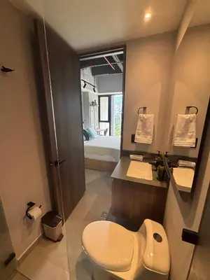 a bathroom with a toilet and a sink and a bed at Apto Bonito Poblado in Medellín