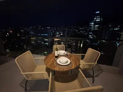 a table and chairs on a balcony at night at Apto Bonito Poblado in Medellín