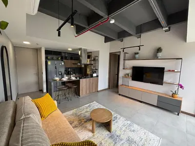 a living room with a couch and a tv at Apto Bonito Poblado in Medellín