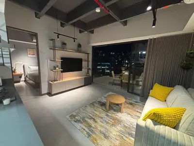 a living room with a white couch and a television at Apto Bonito Poblado in Medellín