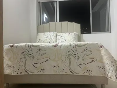 a bed in a bedroom with a white blanket on it at precioso apto para su estadia in Medellín