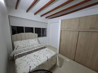 a bedroom with a bed and a wooden cabinet at precioso apto para su estadia in Medellín