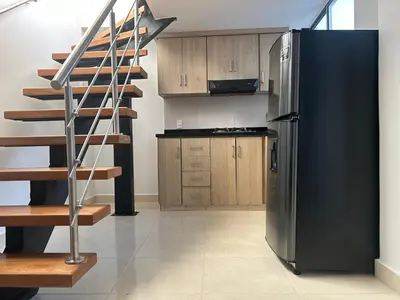 a kitchen with a black refrigerator and a staircase at precioso apto para su estadia in Medellín