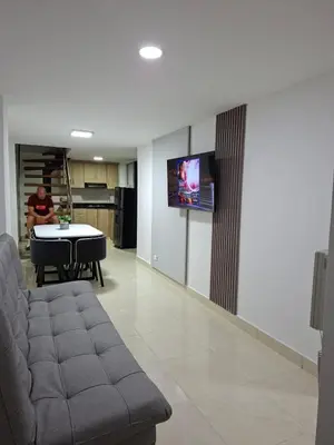 a living room with a couch and a tv on a wall at precioso apto para su estadia in Medellín