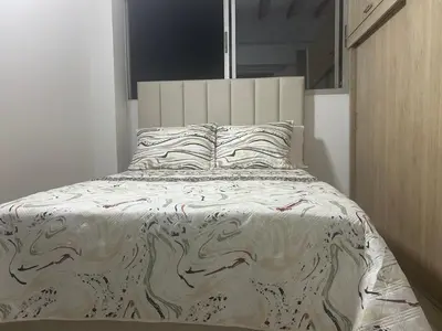 a bedroom with a large bed with a white comforter at precioso apto para su estadia in Medellín
