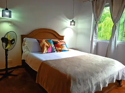 a bedroom with a large bed and a window at Céntrico Apartamento Belén in Medellín