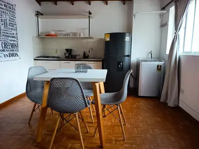 a kitchen with a table and chairs and a refrigerator at Céntrico Apartamento Belén in Medellín