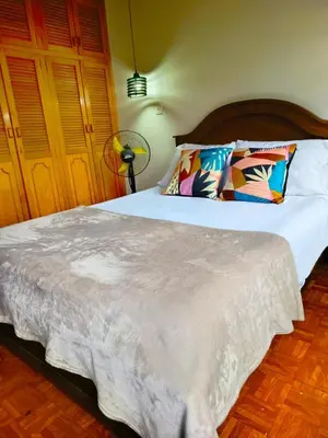 a bedroom with a large bed with a wooden headboard at Céntrico Apartamento Belén in Medellín