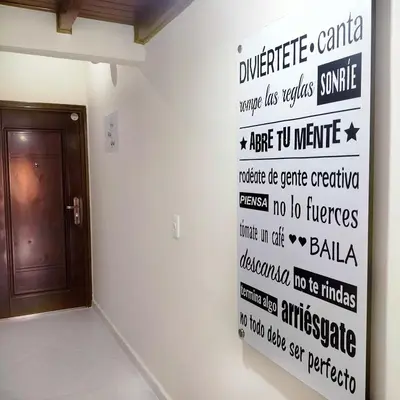 a room with a wall with words on the wall at Céntrico Apartamento Belén in Medellín