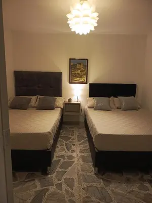 a bedroom with two beds and a chandelier at Casa Manila Medellin in Medellín