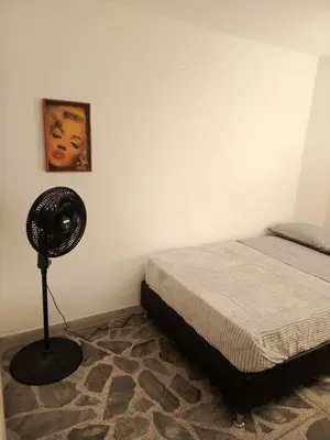 a bedroom with a bed and a fan in a room at Casa Manila Medellin in Medellín