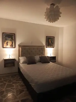 a bedroom with a large bed with two lamps at Casa Manila Medellin in Medellín