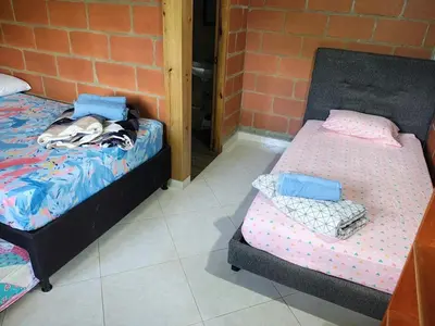 two beds sitting next to a brick wall at Cabaña en San Rafael Cerca de Ríos y Naturaleza in San Rafael