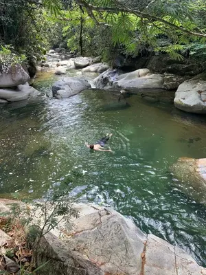 a person swimming in a river near some rocks at Cabaña en San Rafael Cerca de Ríos y Naturaleza in San Rafael