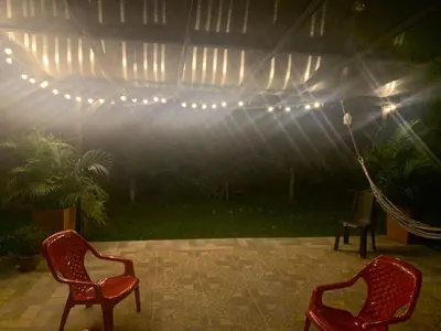 two red chairs sitting on a patio with lights at Cabaña en San Rafael Cerca de Ríos y Naturaleza in San Rafael