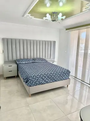 a bedroom with a bed in a white room at Apartamento central y espacioso in Marinilla