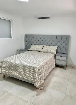 a bedroom with a bed with a blue headboard at Apartamento central y espacioso in Marinilla