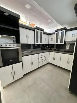 a large kitchen with white cabinets and appliances at Apartamento central y espacioso in Marinilla