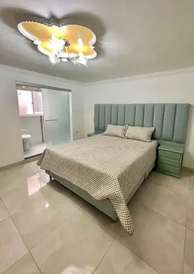 a bedroom with a bed and a chandelier at Apartamento central y espacioso in Marinilla