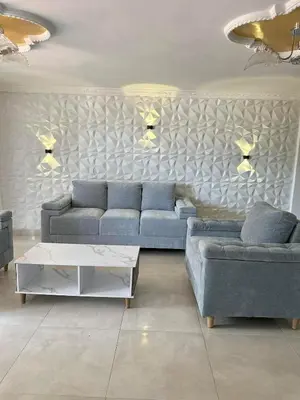 a living room with two blue couches and a table at Apartamento central y espacioso in Marinilla