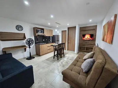 a living room with a couch and a kitchen at Modern Luxury Laureles Life in Medellín