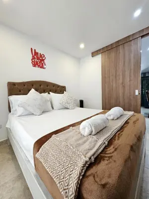 a bedroom with a large bed with two towels on it at Modern Luxury Laureles Life in Medellín