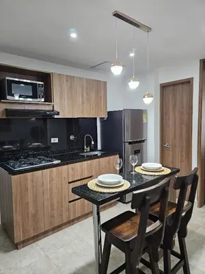 a kitchen with a table with two chairs and a microwave at Modern Luxury Laureles Life in Medellín