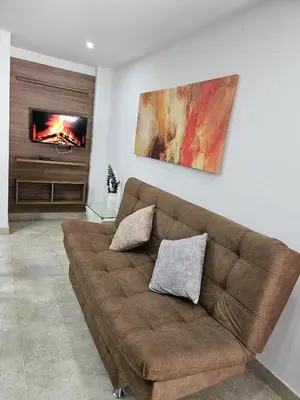 a living room with a brown couch and a fireplace at Modern Luxury Laureles Life in Medellín