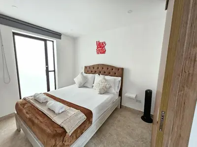 a bedroom with a large bed with white sheets and pillows at Modern Luxury Laureles Life in Medellín