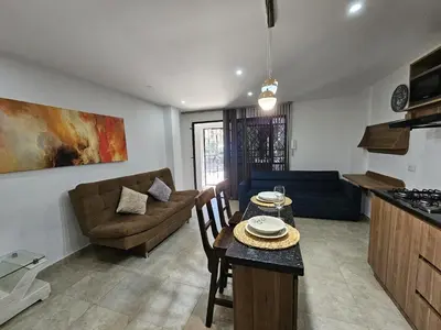 a kitchen and living room with a table and a couch at Modern Luxury Laureles Life in Medellín