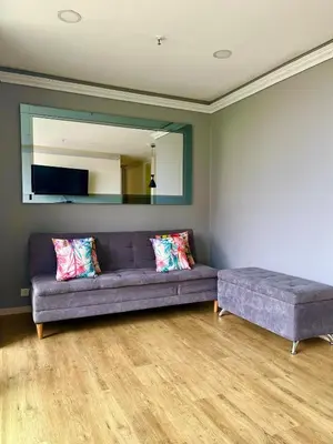 a living room with a couch and a large mirror at El Poblado, Balcony, Pool, Jacuzzi, Gym, Steamroom in Medellín