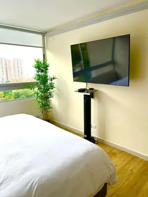 a bedroom with a bed and a flat screen tv at El Poblado, Balcony, Pool, Jacuzzi, Gym, Steamroom in Medellín